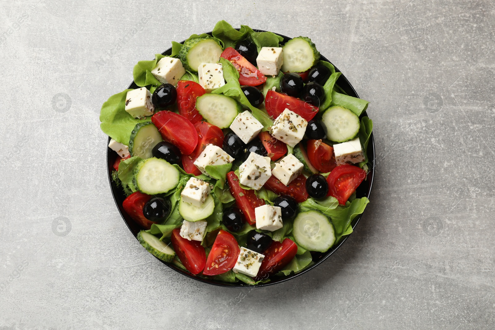 Photo of Delicious salad with feta cheese on grey table, top view