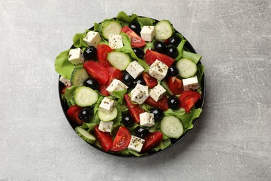 Delicious salad with feta cheese on grey table, top view