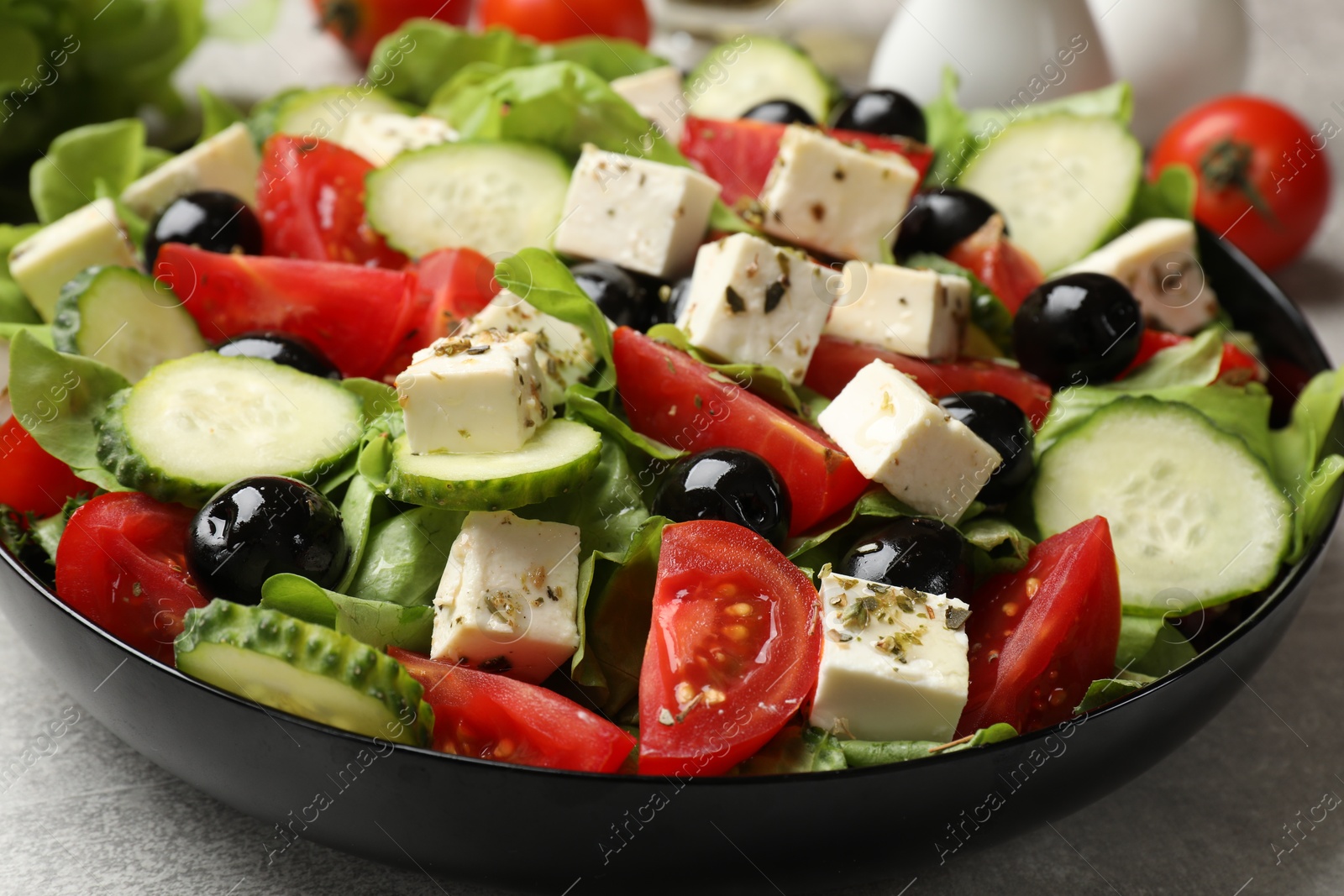 Photo of Delicious salad with feta cheese on grey table, closeup