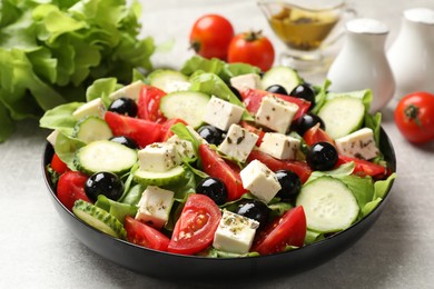 Photo of Delicious salad with feta cheese on grey table, closeup