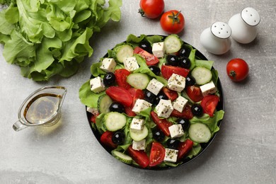 Delicious salad with feta cheese and ingredients on grey table, flat lay