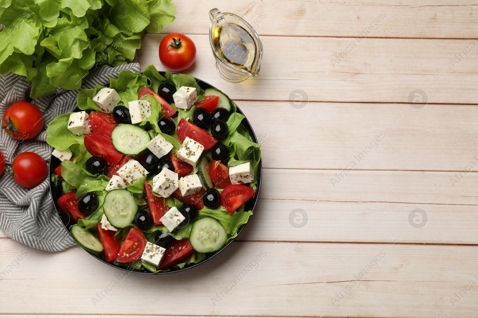 Photo of Delicious salad with feta cheese and ingredients on white wooden table, flat lay. Space for text