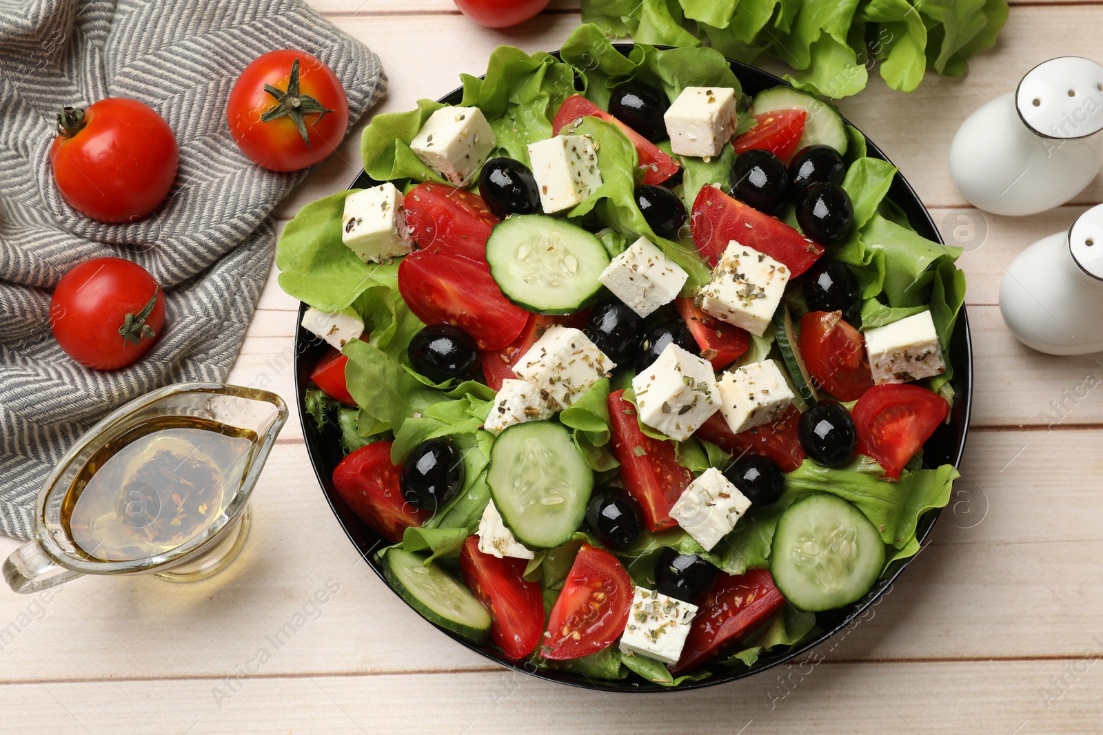 Photo of Delicious salad with feta cheese and ingredients on white wooden table, flat lay