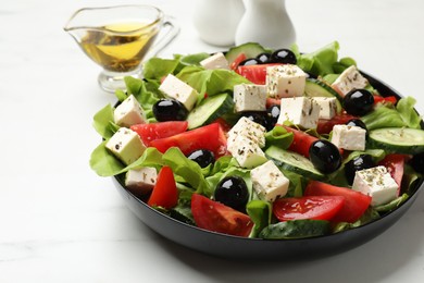 Photo of Delicious salad with feta cheese served on white marble table, closeup