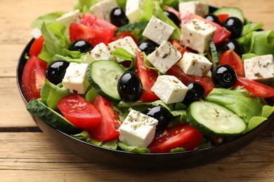 Photo of Delicious salad with feta cheese on wooden table, closeup