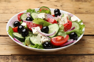 Photo of Delicious salad with feta cheese on wooden table, closeup