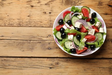 Photo of Delicious salad with feta cheese on wooden table, top view. Space for text