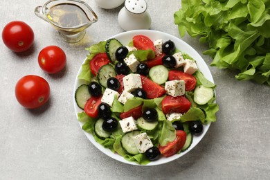 Photo of Delicious salad with feta cheese and ingredients on grey table, flat lay