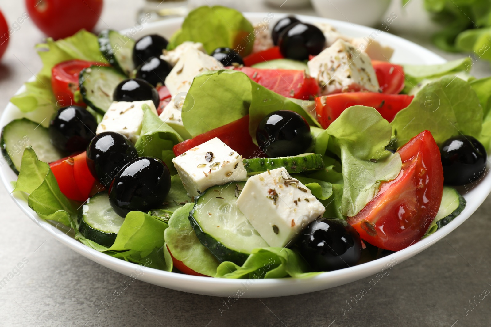 Photo of Delicious salad with feta cheese on grey table, closeup