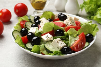 Photo of Delicious salad with feta cheese on grey table, closeup