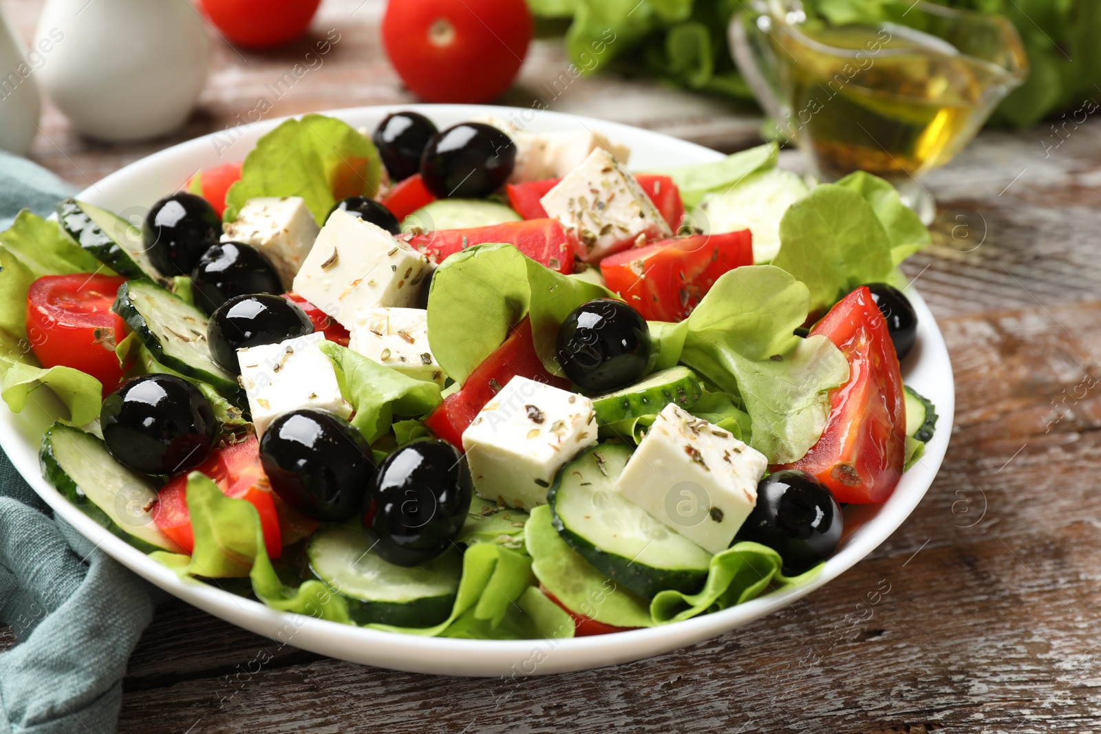 Photo of Delicious salad with feta cheese on wooden table, closeup