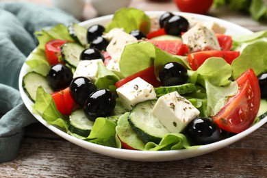 Photo of Delicious salad with feta cheese on wooden table, closeup