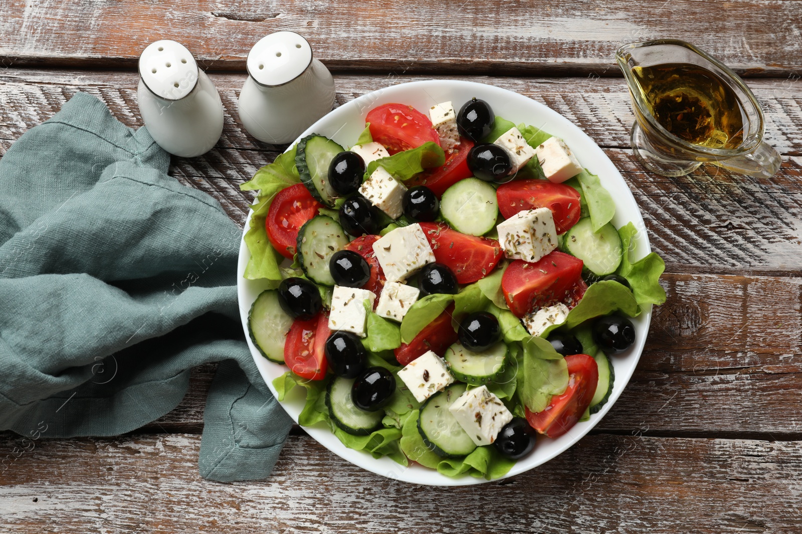 Photo of Delicious salad with feta cheese served on wooden table, flat lay