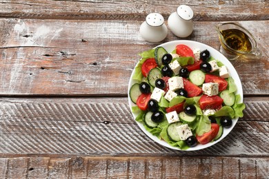 Photo of Delicious salad with feta cheese served on wooden table, flat lay. Space for text