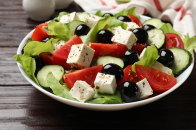 Photo of Delicious salad with feta cheese on wooden table, closeup