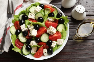 Photo of Delicious salad with feta cheese served on wooden table, flat lay