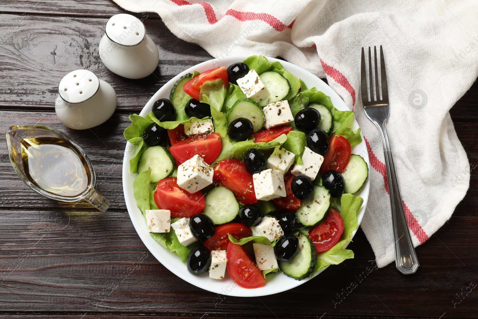 Photo of Delicious salad with feta cheese served on wooden table, flat lay