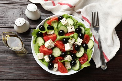 Photo of Delicious salad with feta cheese served on wooden table, flat lay