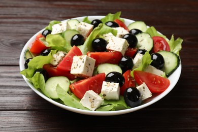 Photo of Delicious salad with feta cheese on wooden table, closeup