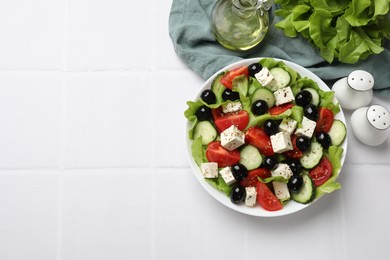 Photo of Delicious salad with feta cheese served on white tiled table, flat lay. Space for text