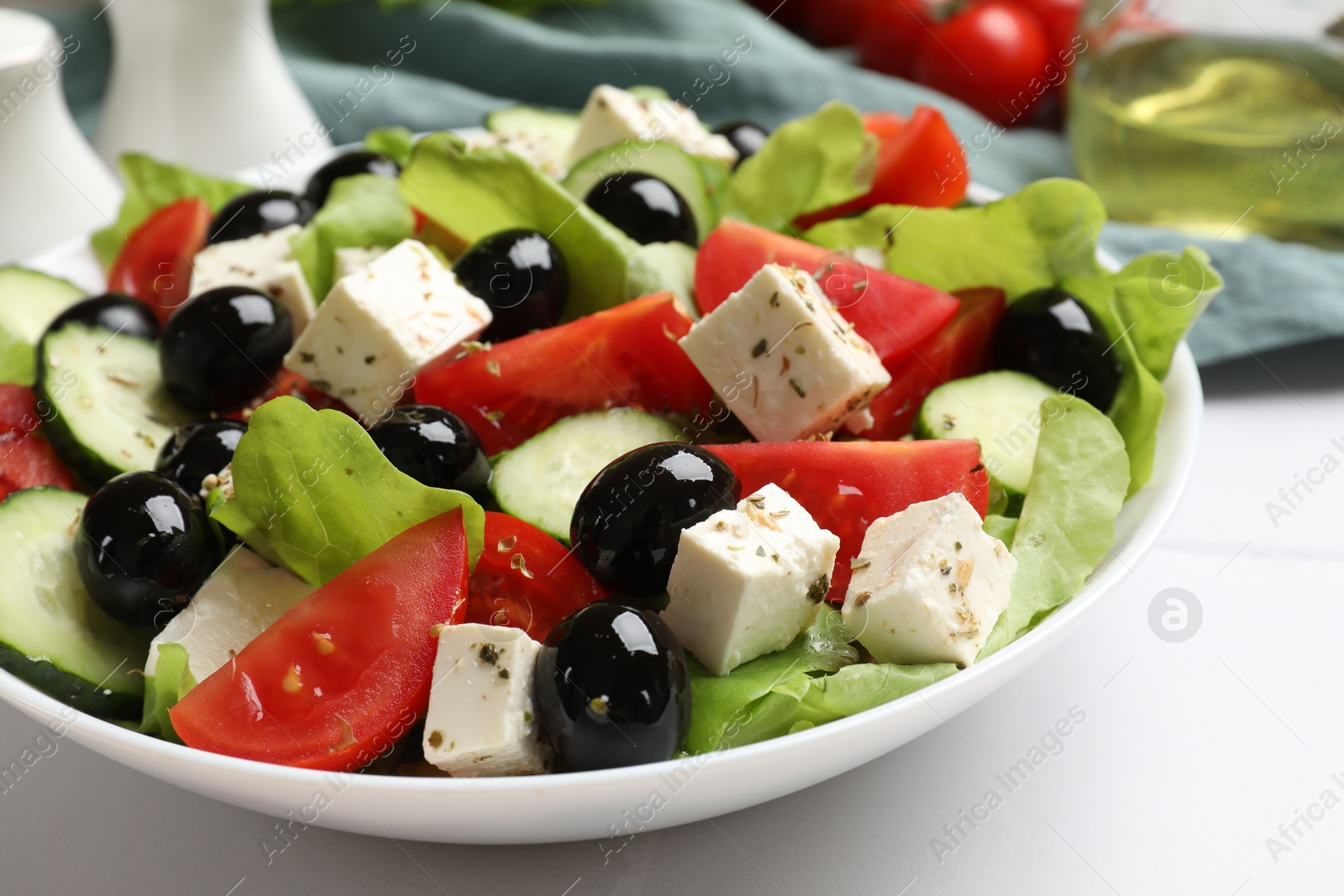 Photo of Delicious salad with feta cheese on white tiled table, closeup