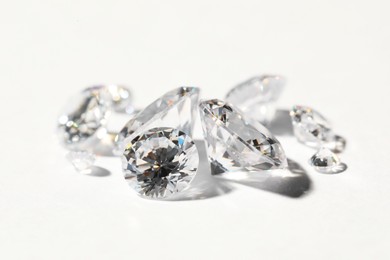 Many beautiful shiny diamonds on white background, closeup