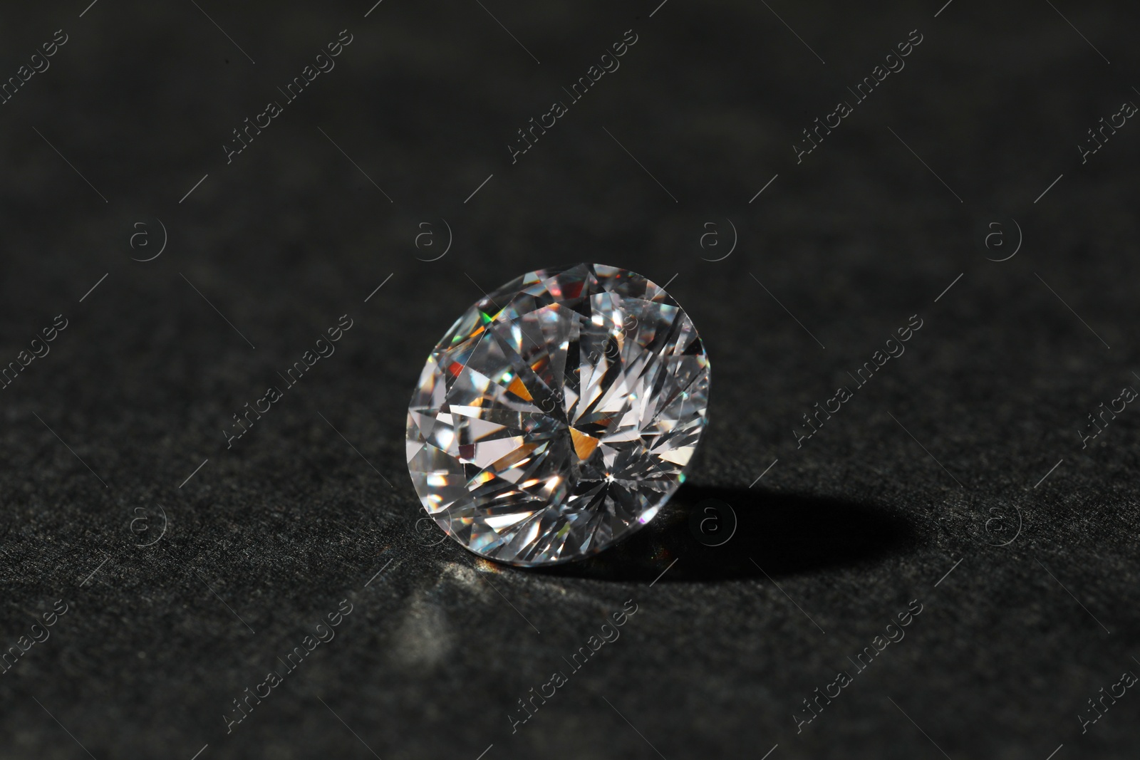 Photo of Beautiful shiny diamond on black table, closeup