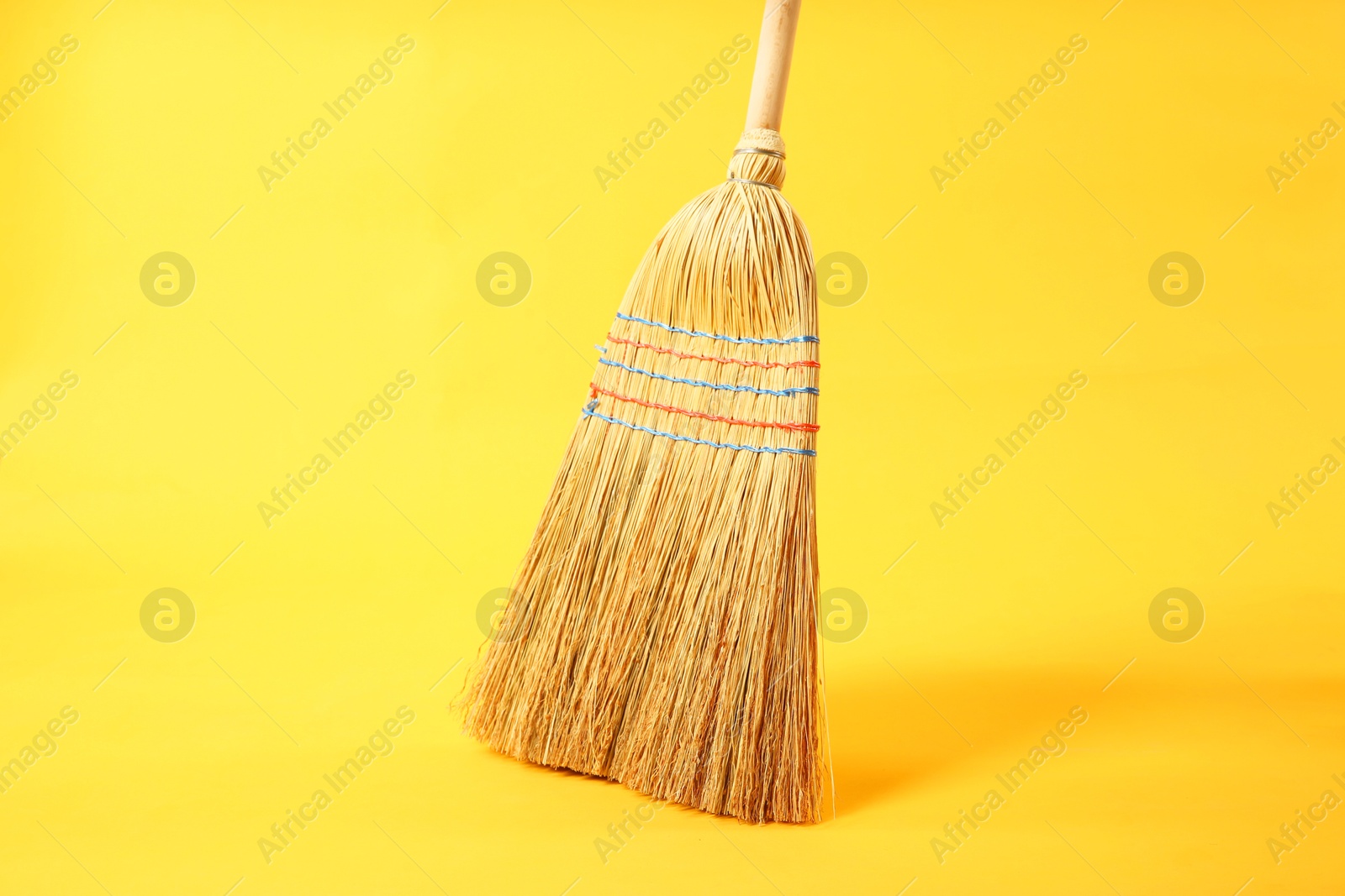 Photo of One corn straw broom on yellow background