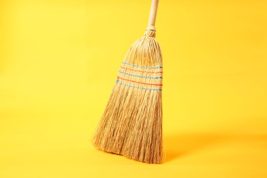 Photo of One corn straw broom on yellow background