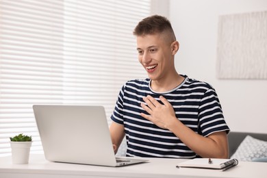 Young man using sign language during video call indoors