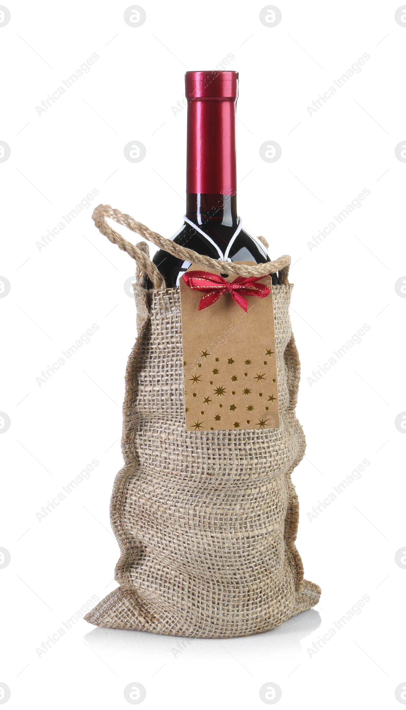 Photo of Wine bottle in burlap bag with cardboard tag isolated on white