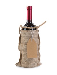 Wine bottle in burlap bag with cardboard tag isolated on white