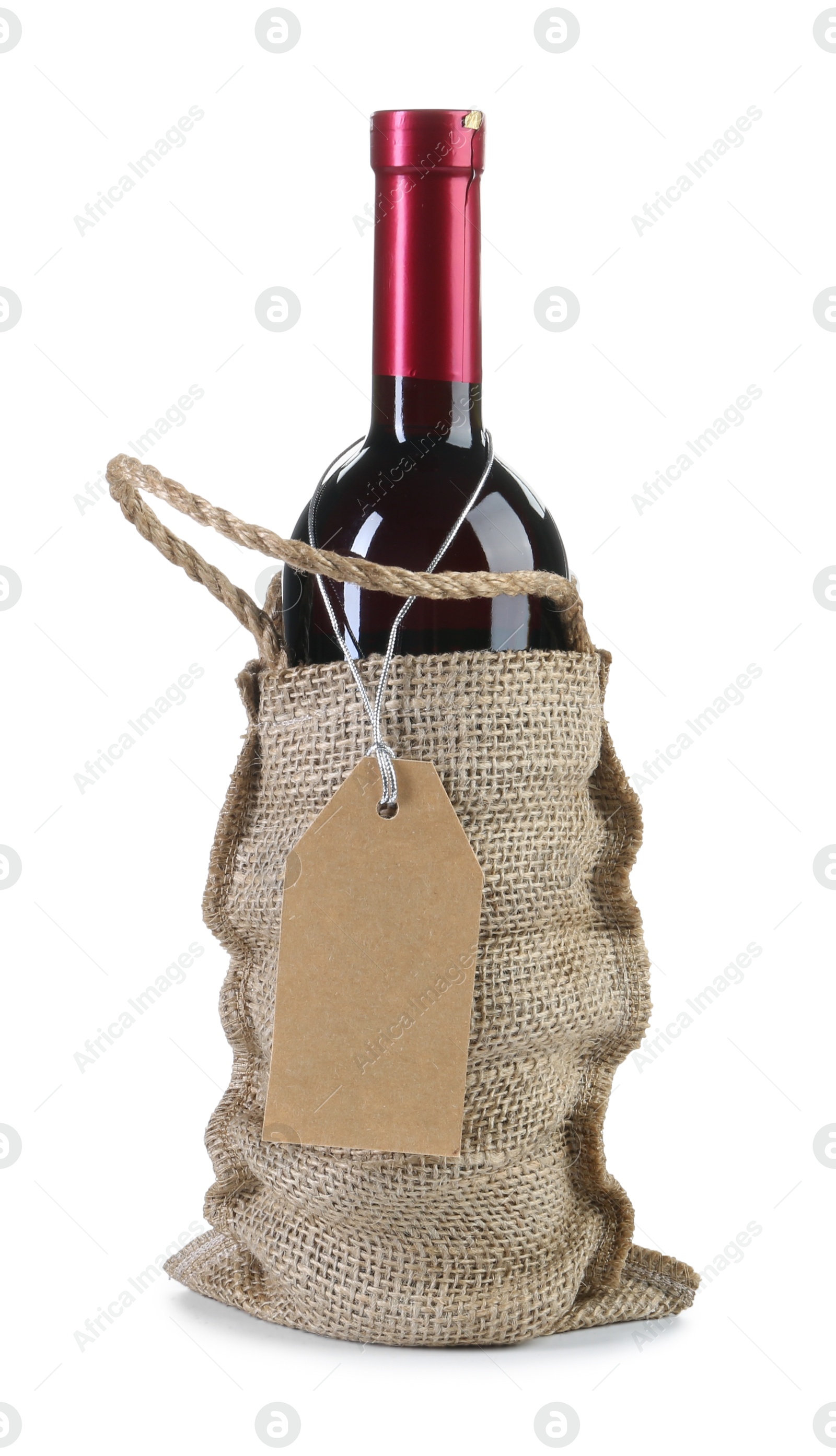 Photo of Wine bottle in burlap bag with cardboard tag isolated on white