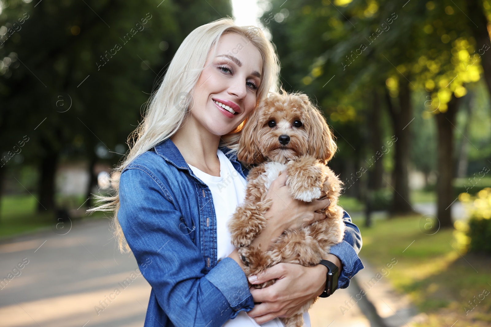 Photo of Portrait of beautiful young woman with cute dog in park