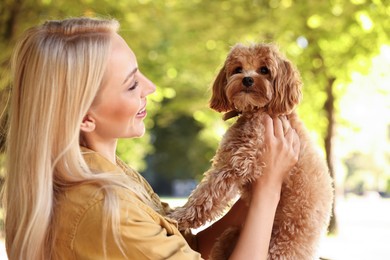 Beautiful young woman with cute dog in park