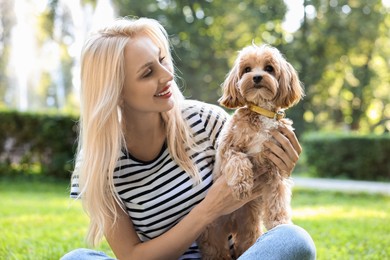 Photo of Beautiful young woman with cute dog in park