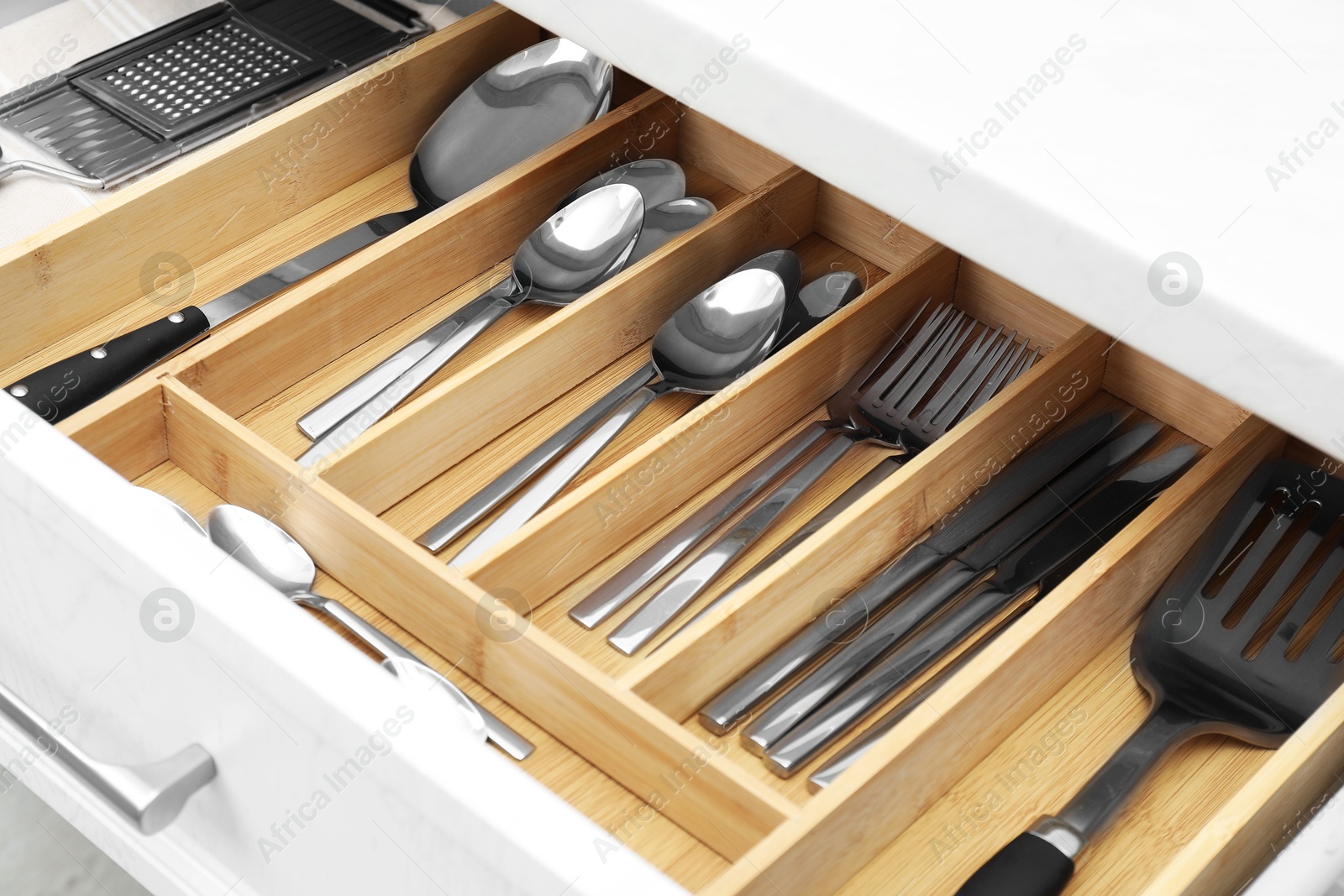 Photo of Box with cutlery in drawer, closeup. Kitchen utensils storage