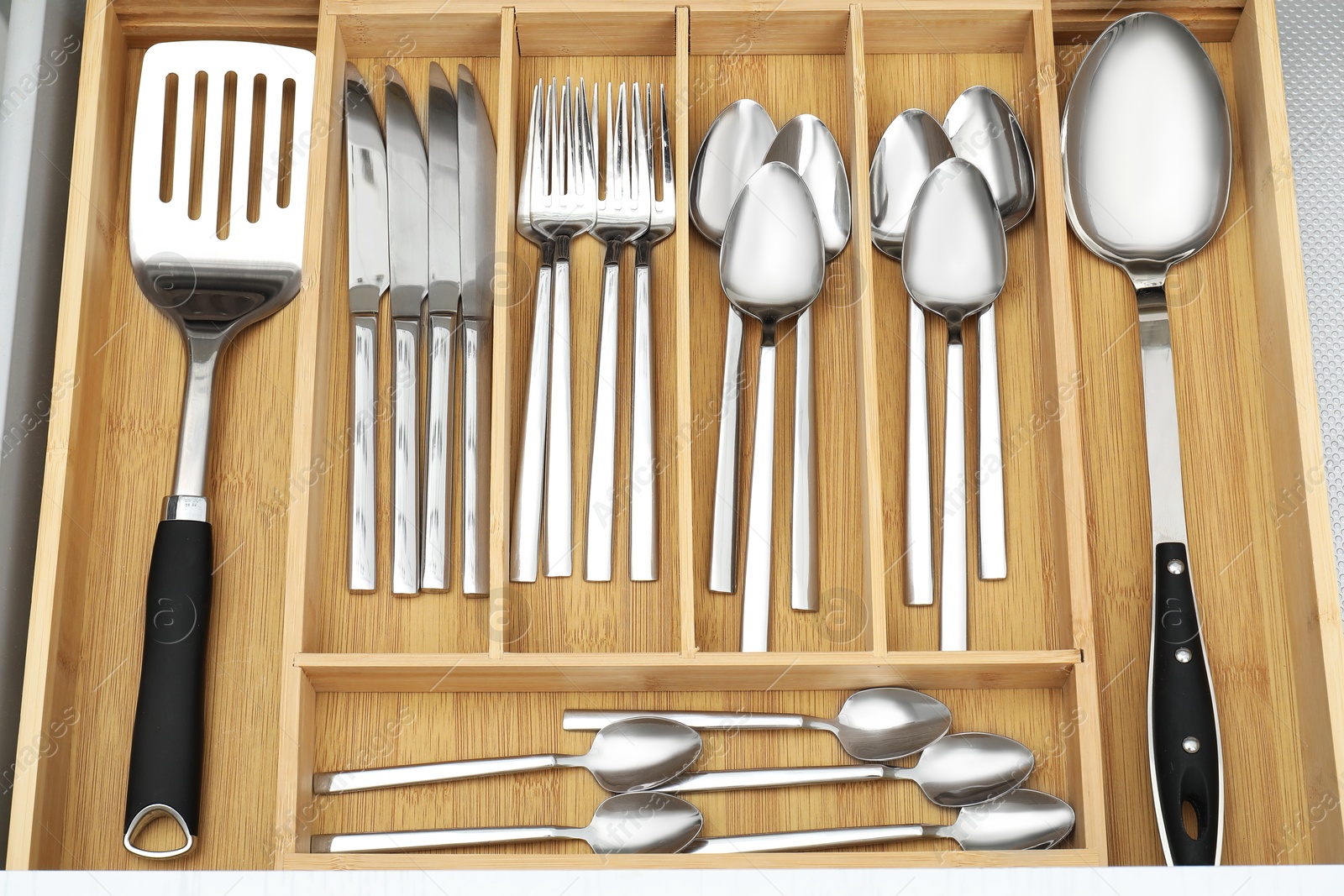 Photo of Box with cutlery in drawer, above view. Kitchen utensils storage