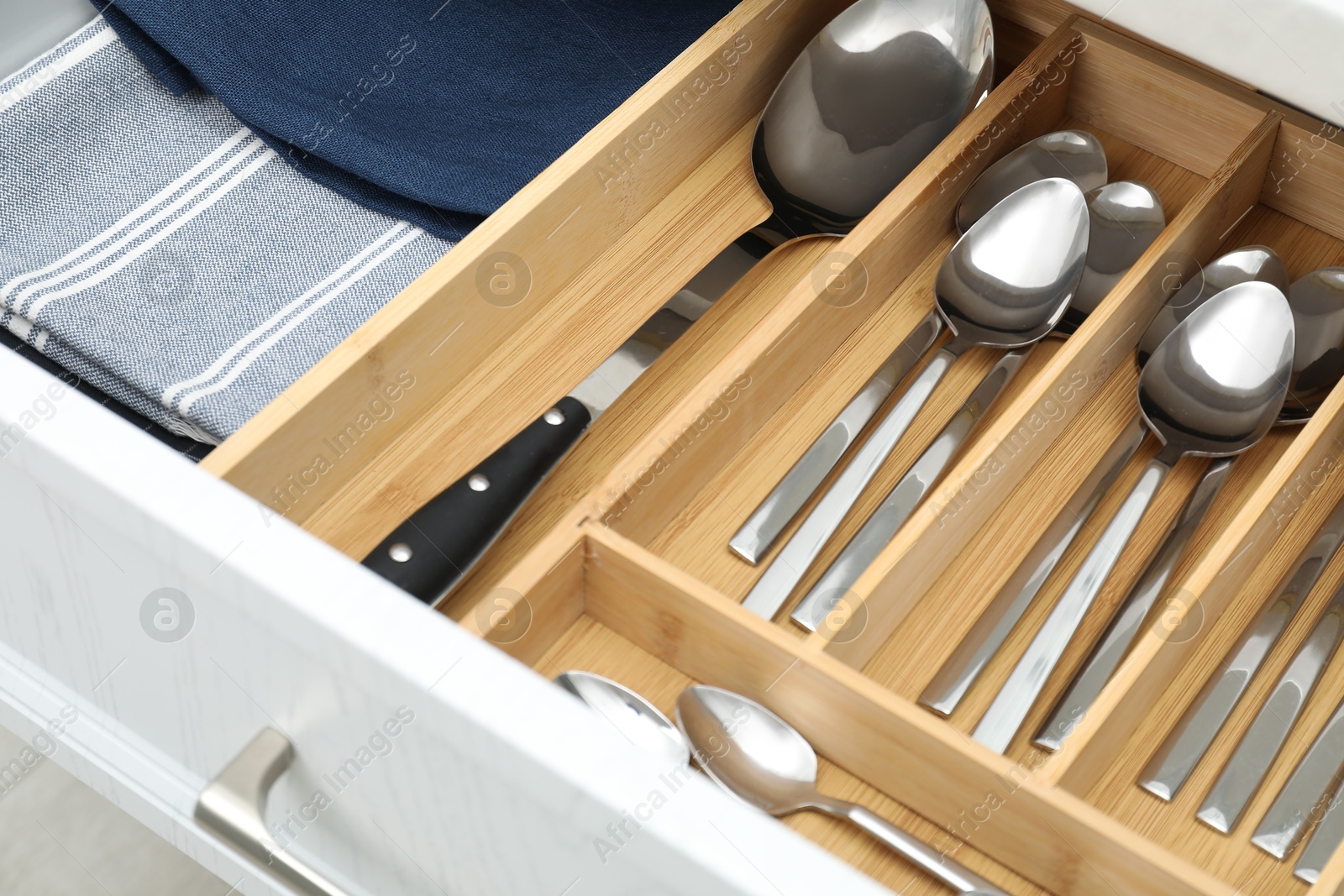 Photo of Box with cutlery in drawer, closeup. Kitchen utensils storage