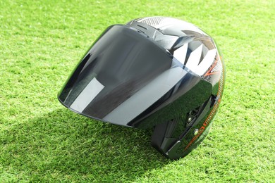 Modern motorcycle helmet with visor on green grass outdoors