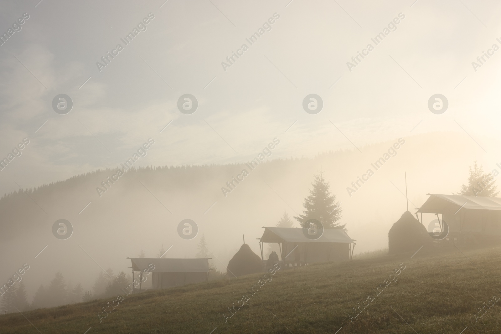 Photo of Many houses and beautiful mountains covered with fog in morning