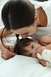 Photo of Beautiful young mother with her cute little baby on bed