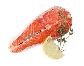 Photo of Fresh salmon steak, lemon and thyme isolated on white, top view