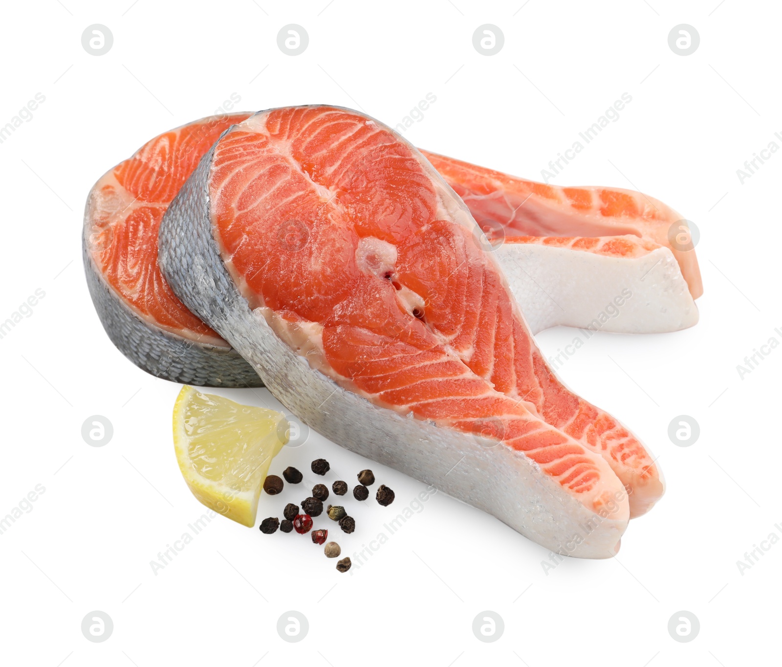 Photo of Two fresh salmon steaks, lemon and peppercorns isolated on white