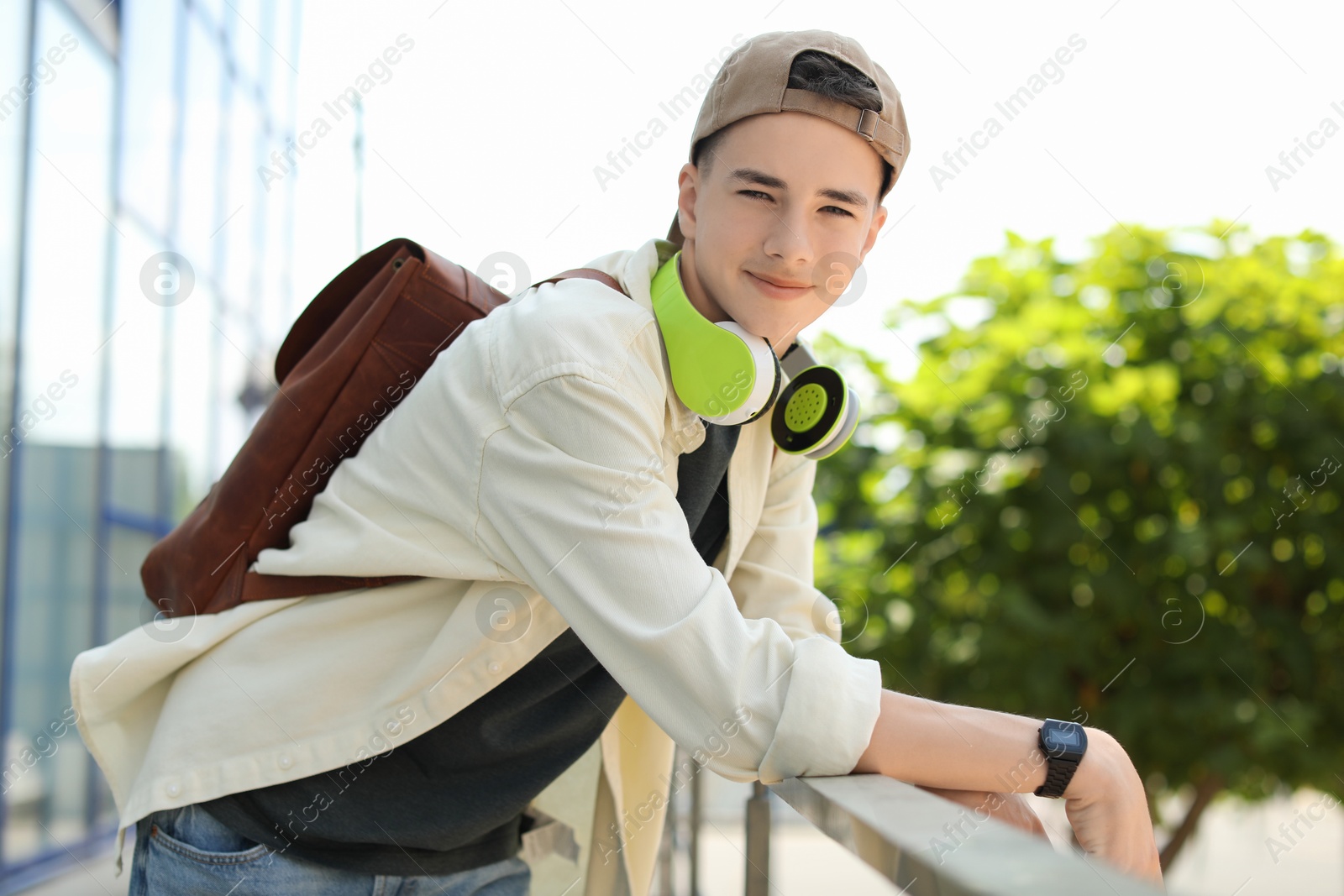 Photo of Portrait of teenage boy with headphones outdoors