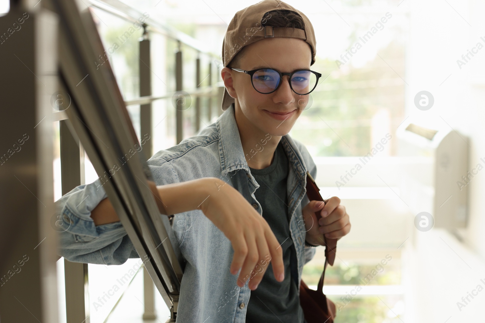 Photo of Portrait of teenage boy near railings indoors