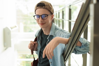 Photo of Portrait of teenage boy near railings indoors