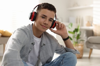 Photo of Portrait of teenage boy listening to music at home