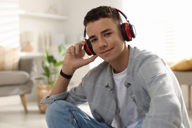 Portrait of teenage boy listening to music at home