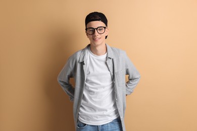 Photo of Portrait of smiling teenage boy on dark beige background